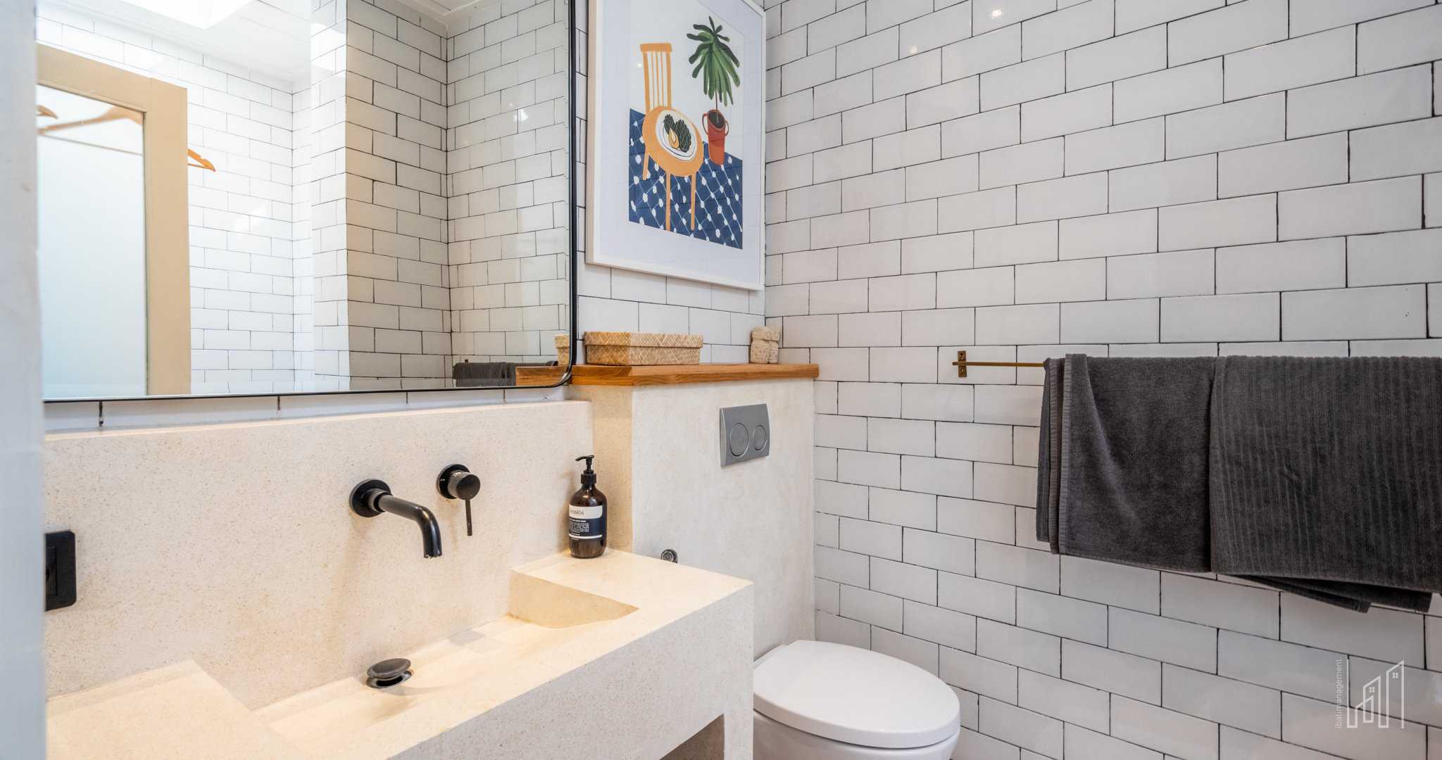 Modern bathroom with subway tiles and artwork.
