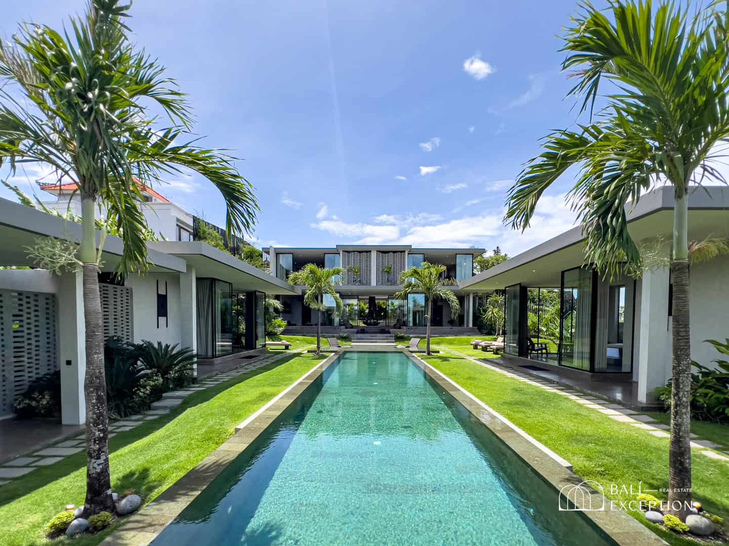 Luxury villa with pool and palm trees.
