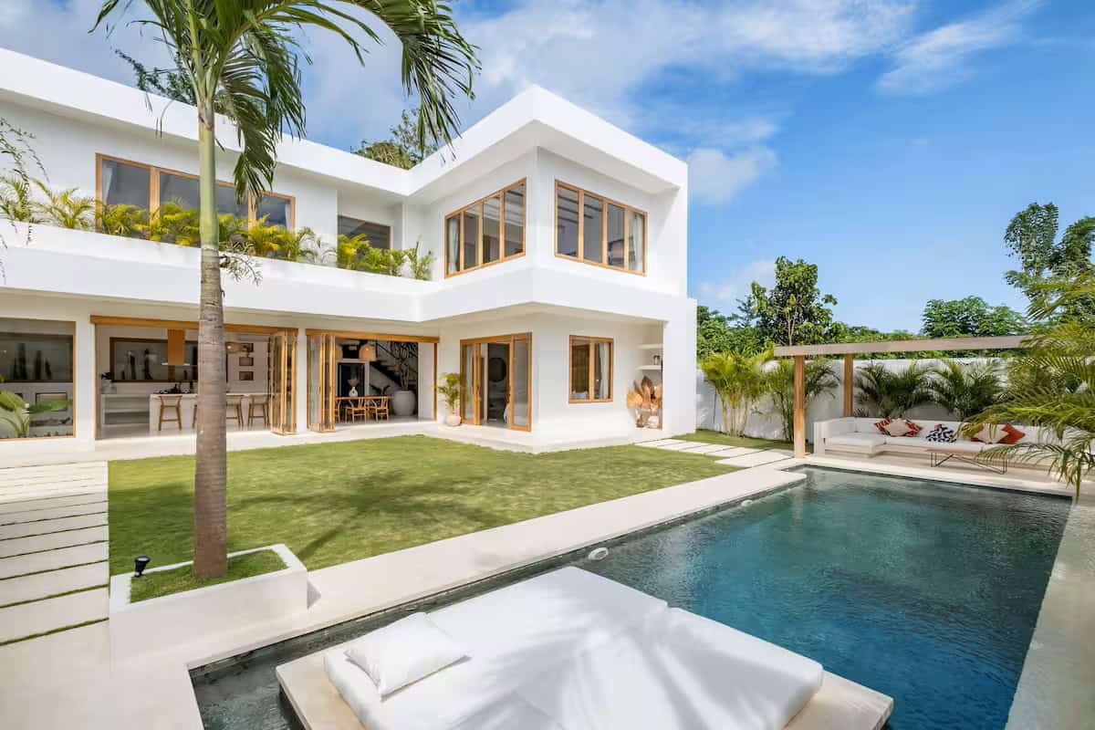 Modern white villa with pool and palm tree