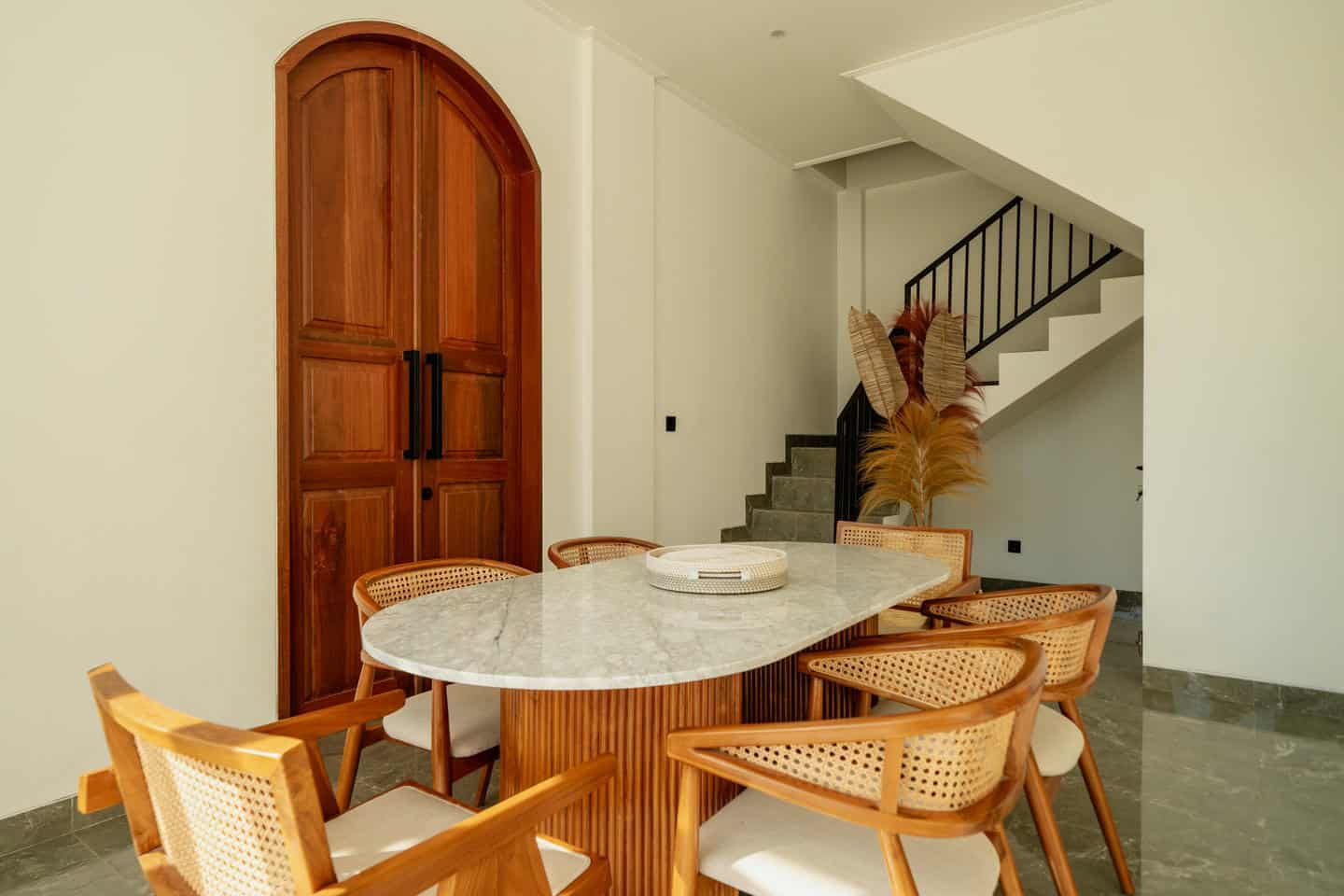 Modern dining area with wooden chairs and table.