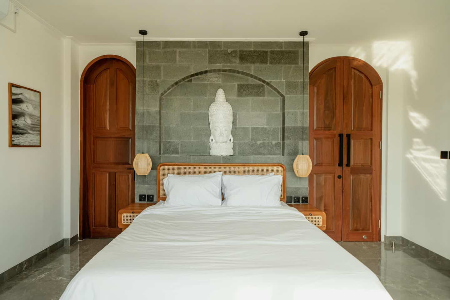 Cozy bedroom with Buddha sculpture and wooden doors.