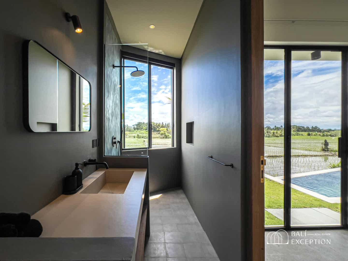 Modern bathroom with countryside view and pool access.