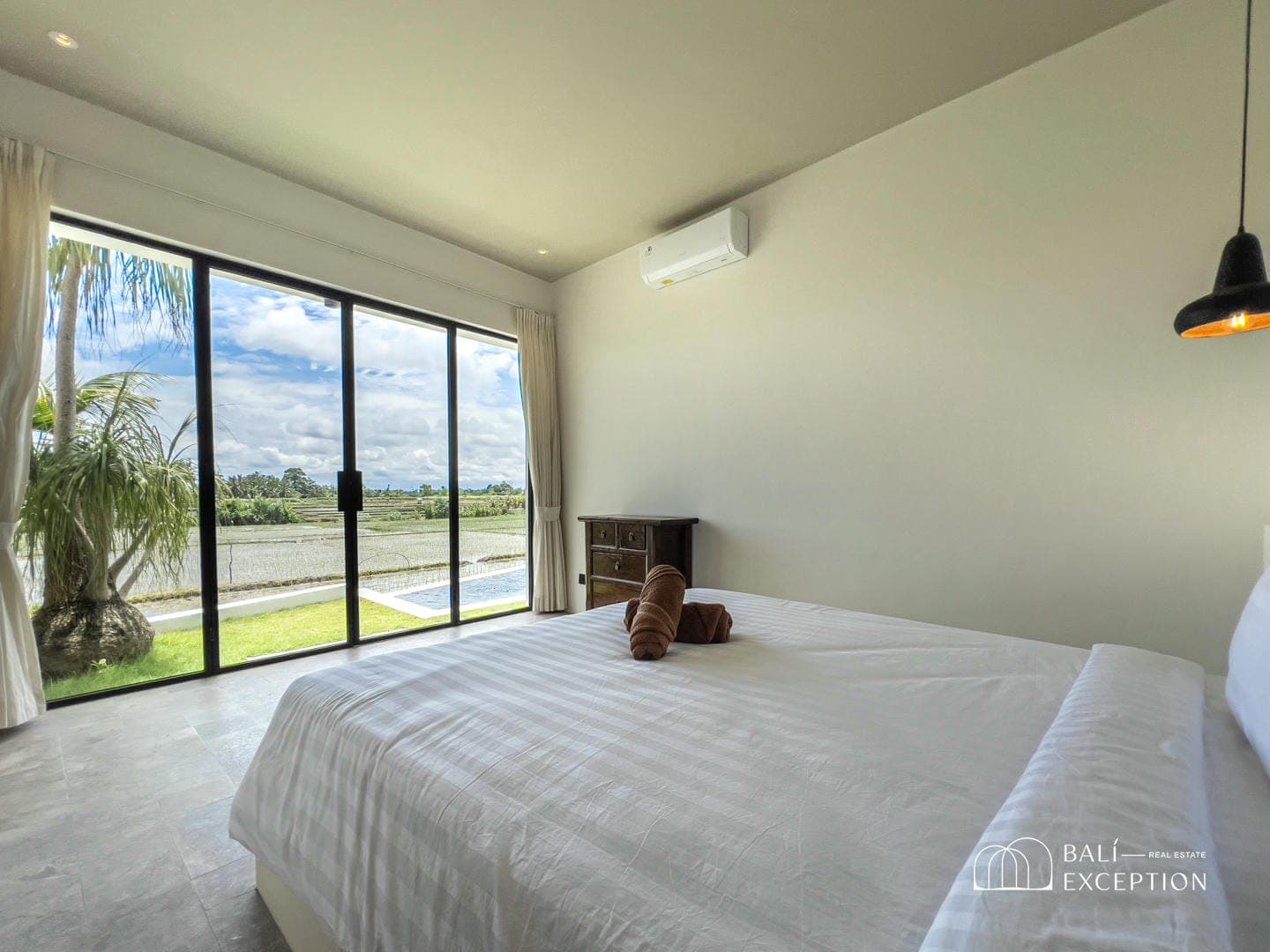 Minimalist bedroom with large window and scenic view.