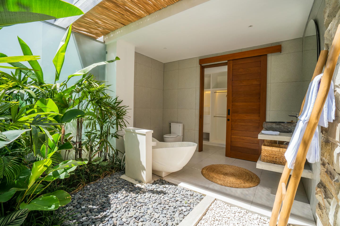 Outdoor bathroom with bathtub and greenery