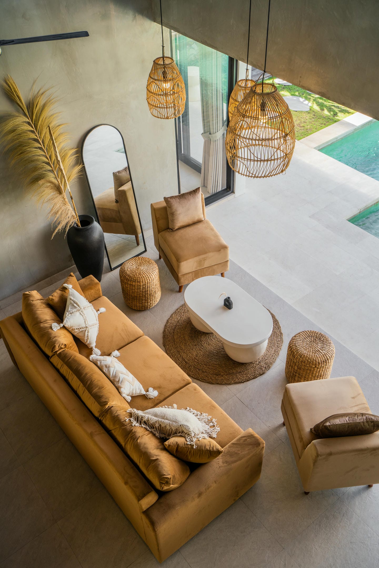 Modern living room with beige furniture and pool view.