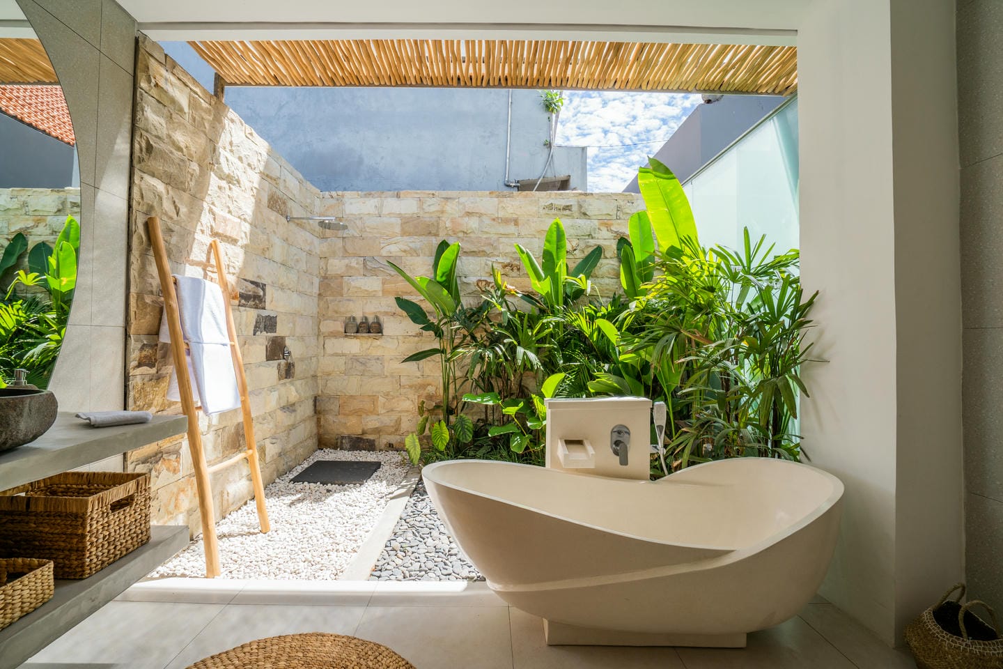 Luxurious outdoor bathroom with plants and bathtub