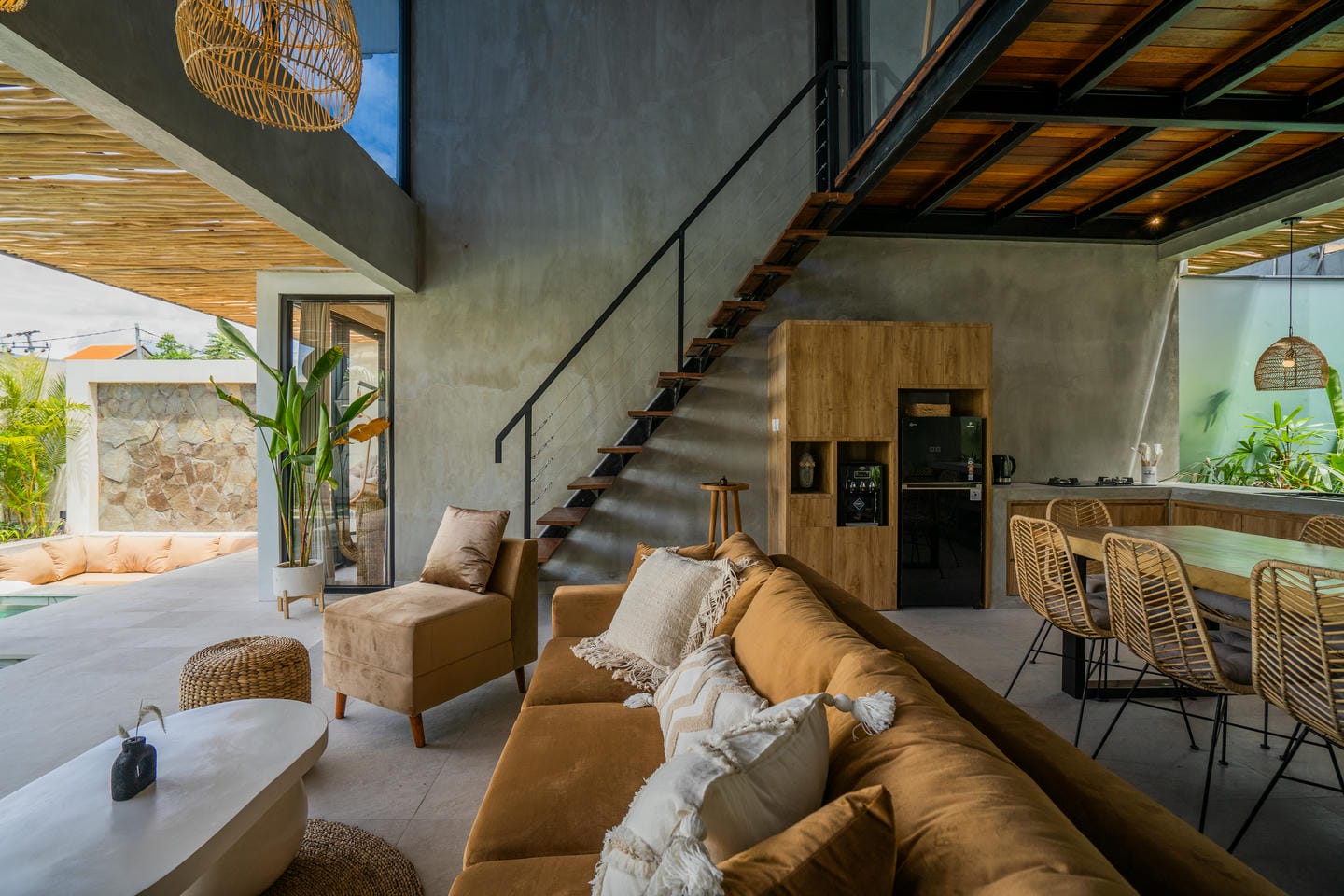 Modern open living room with kitchen and staircase.