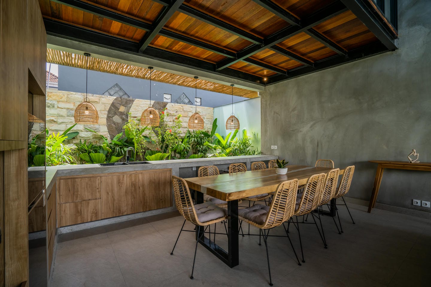 Outdoor dining area with wooden table and plants.