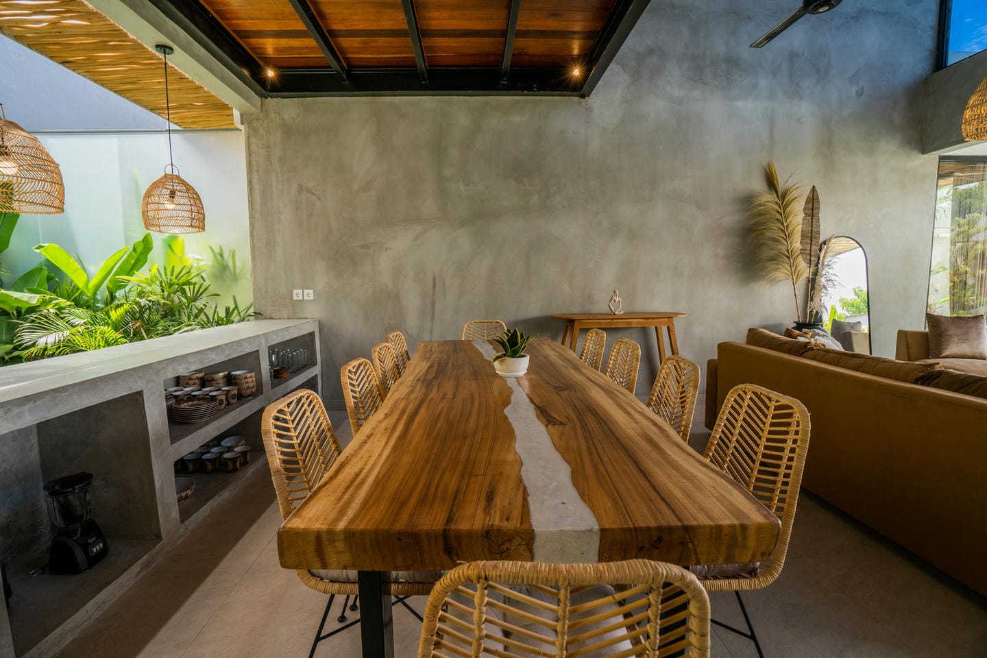 Modern dining area with wooden table and wicker chairs.