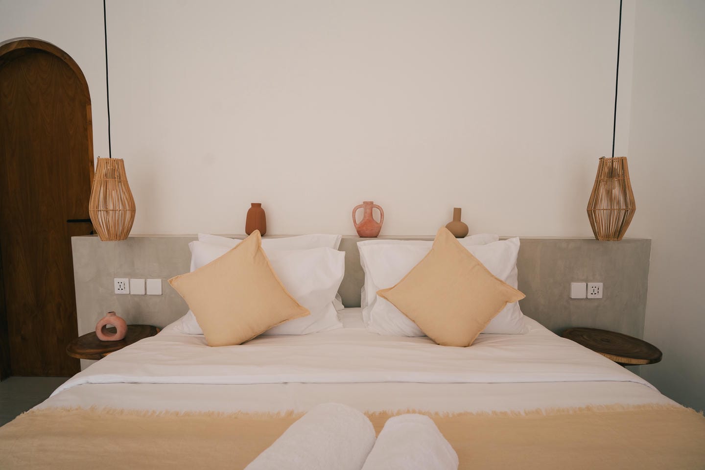 Cozy bedroom with pillows and decorative vases.