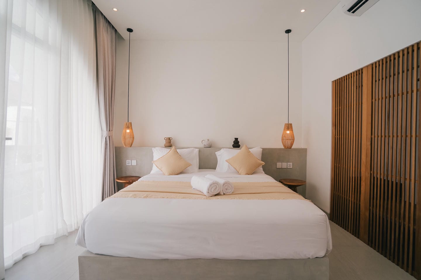 Modern bedroom with double bed and soft lighting.