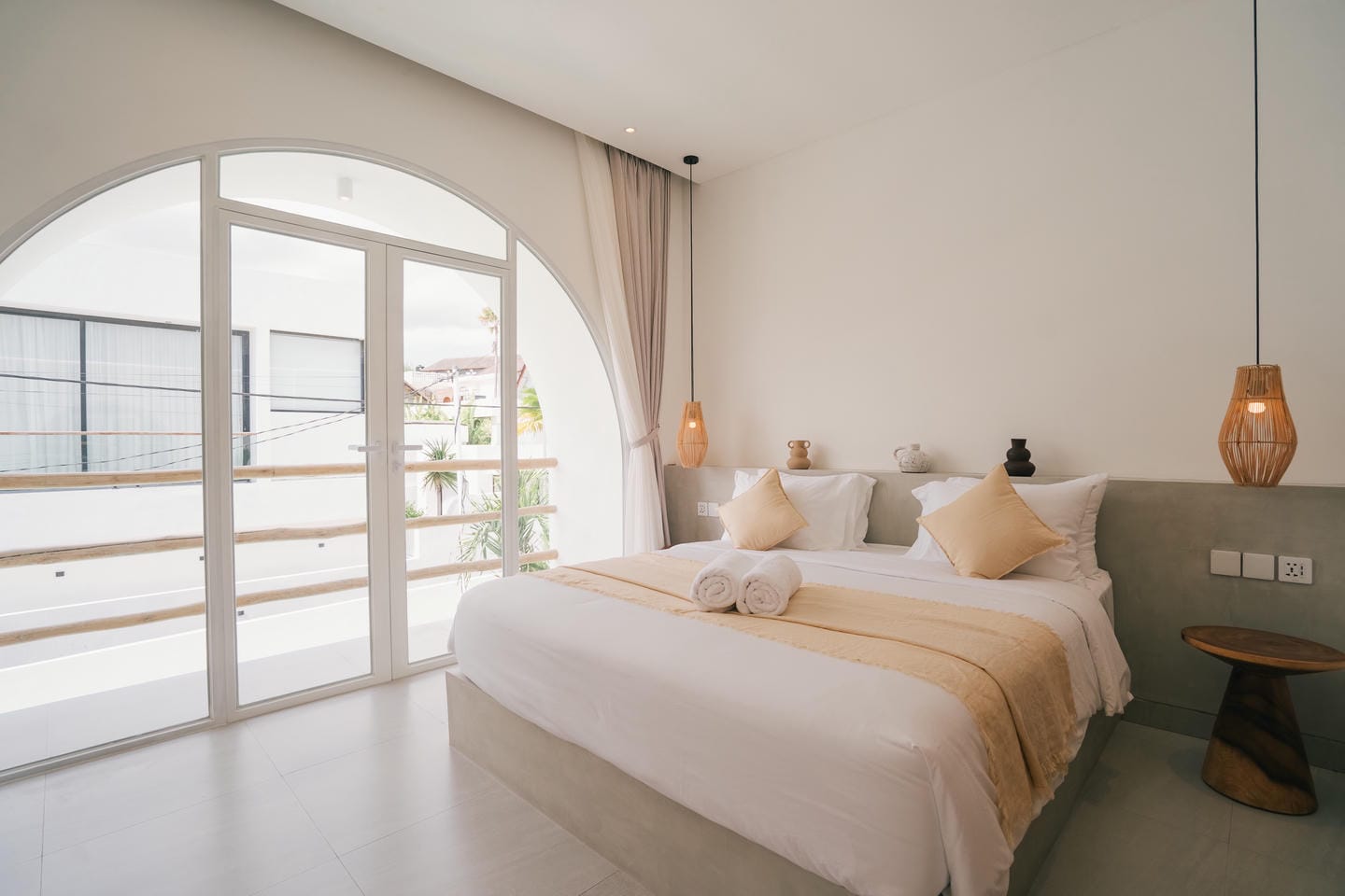 Modern bedroom with balcony view and cozy decor.