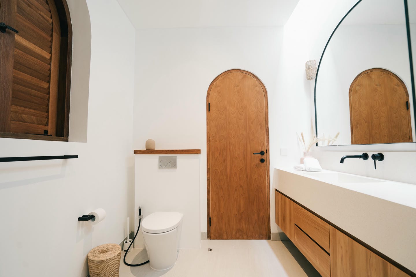 Modern bathroom with wooden door and mirror