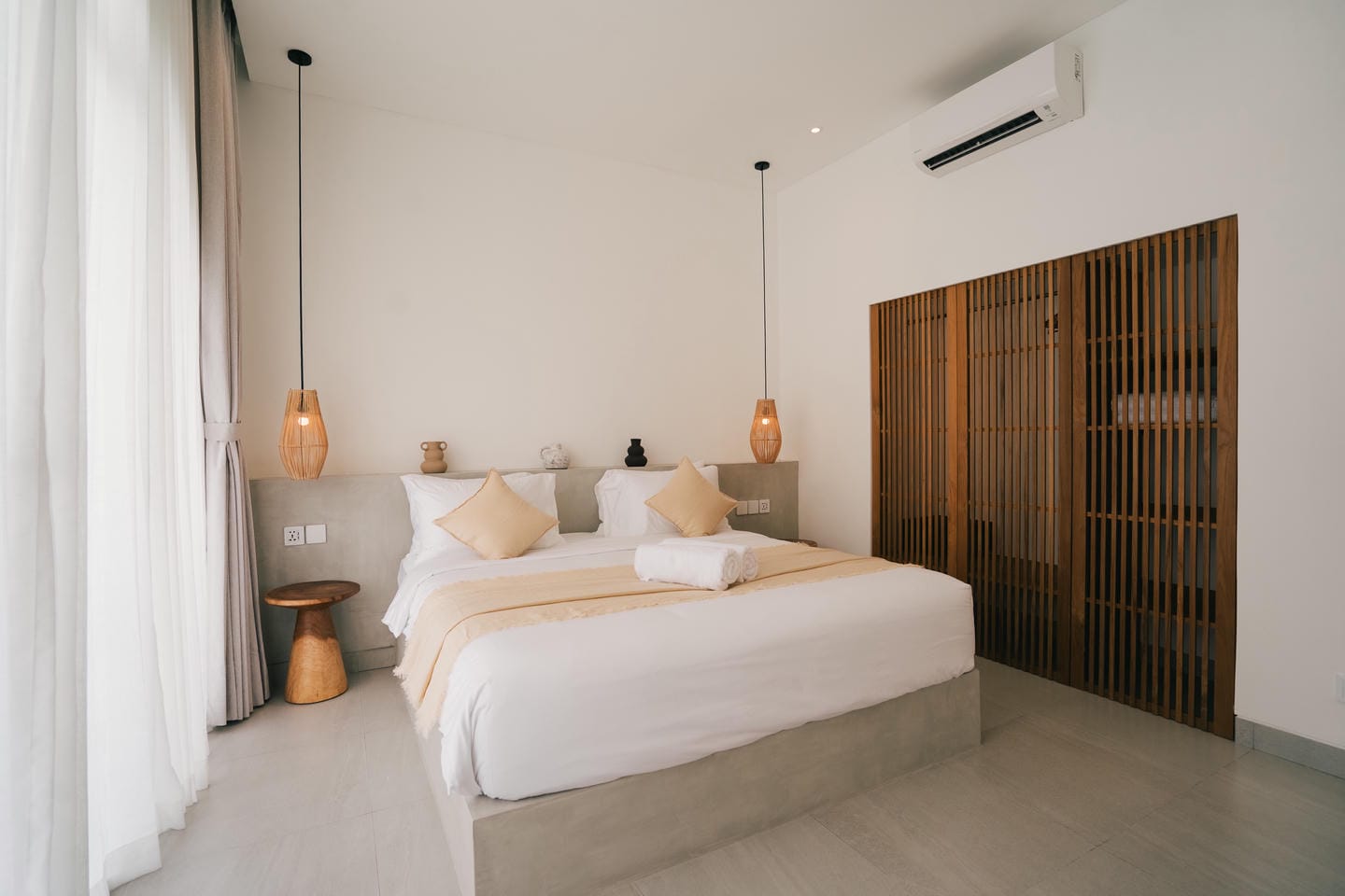 Modern bedroom with double bed and wooden accents.