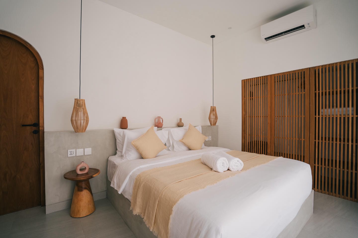 Minimalist bedroom with double bed and wooden accents.