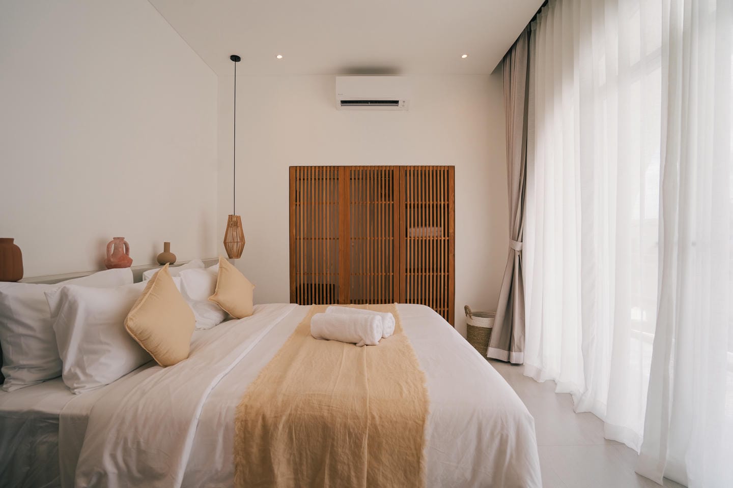 Minimalist bedroom with cozy bed and natural light.
