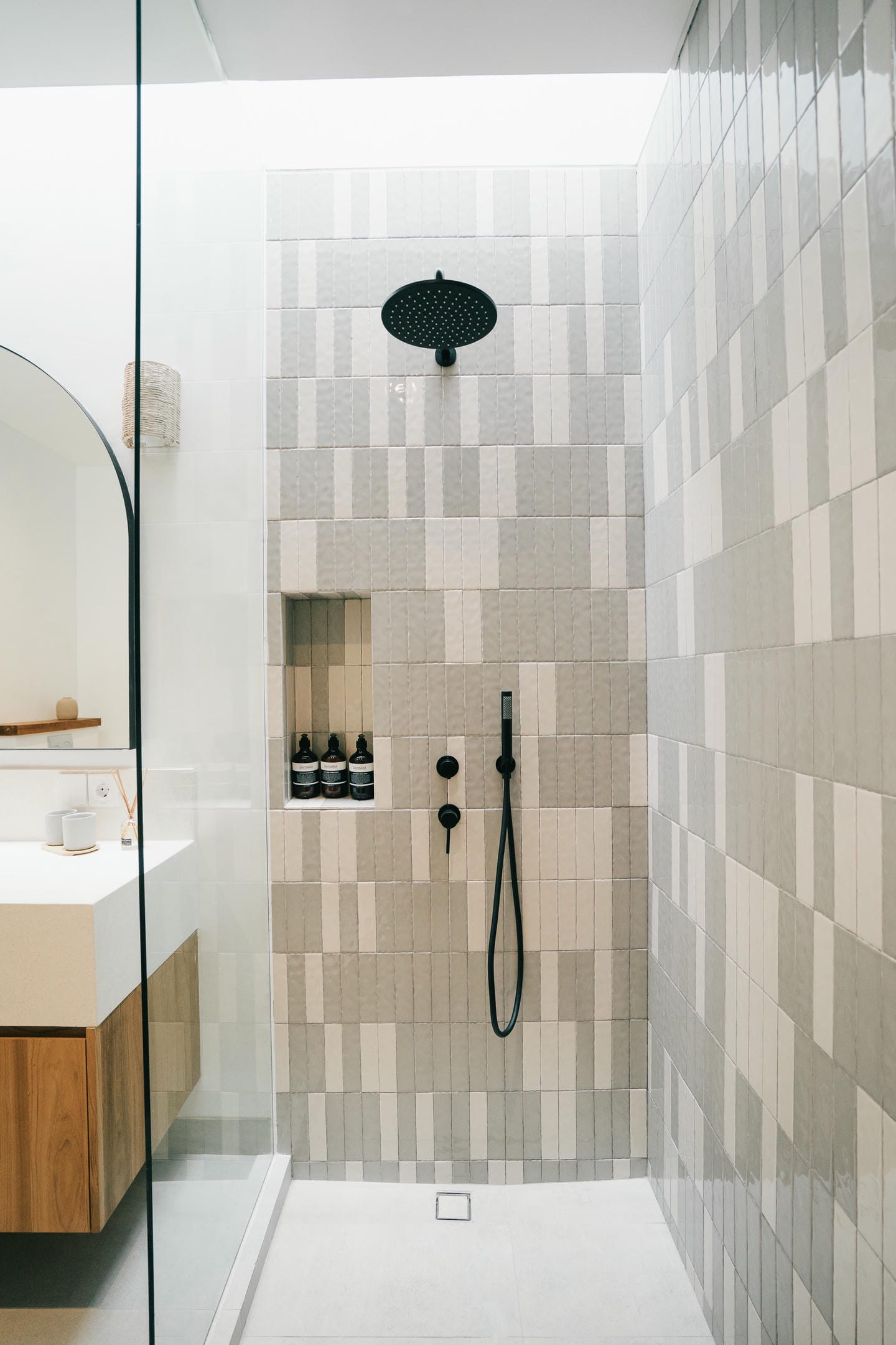 Modern bathroom with tiled shower and black fixtures.