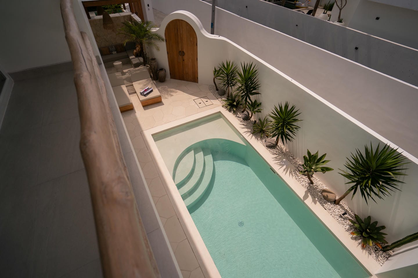 Modern courtyard with pool and lush greenery.