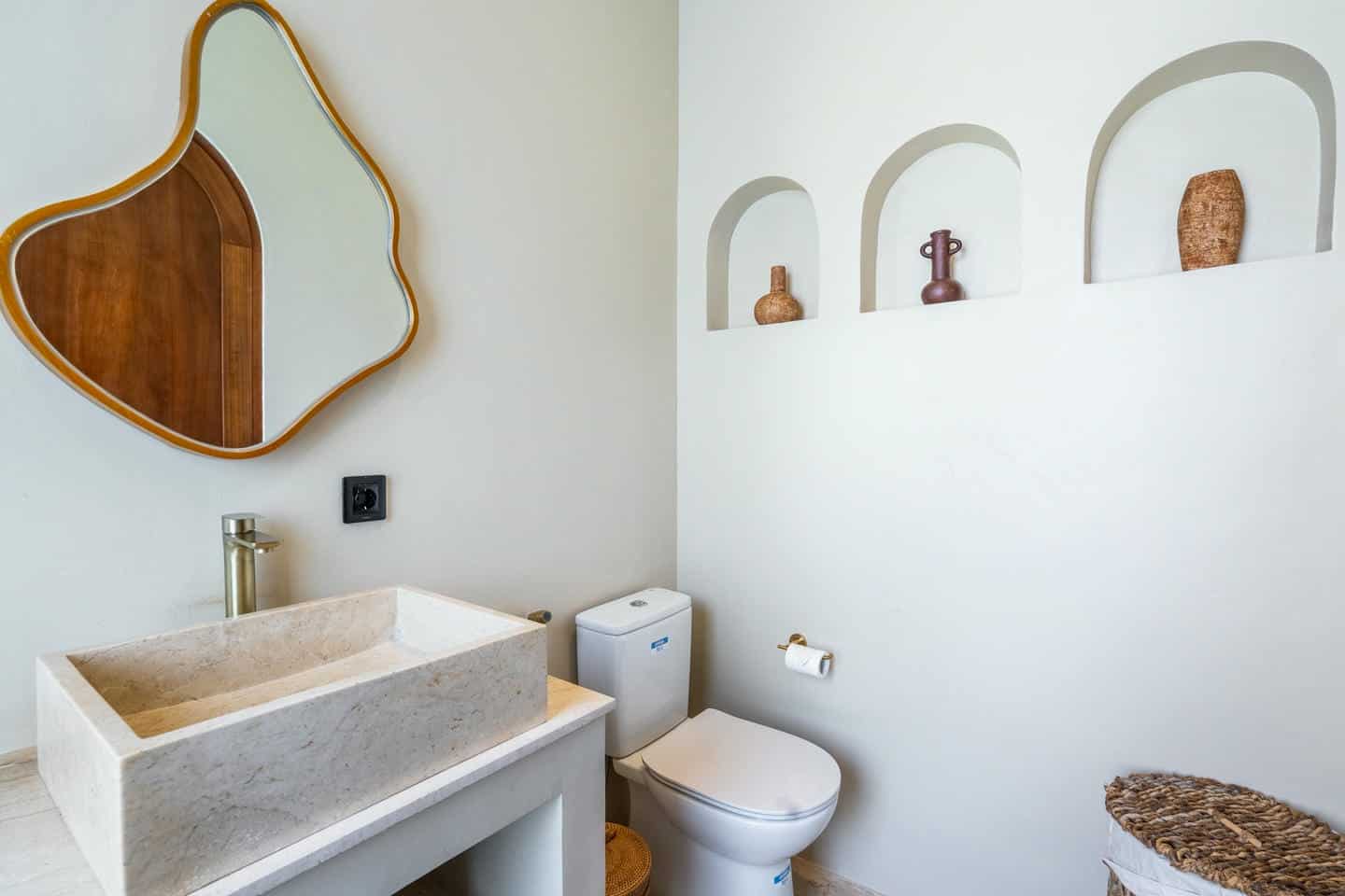 Modern bathroom with unique mirror and vase decor