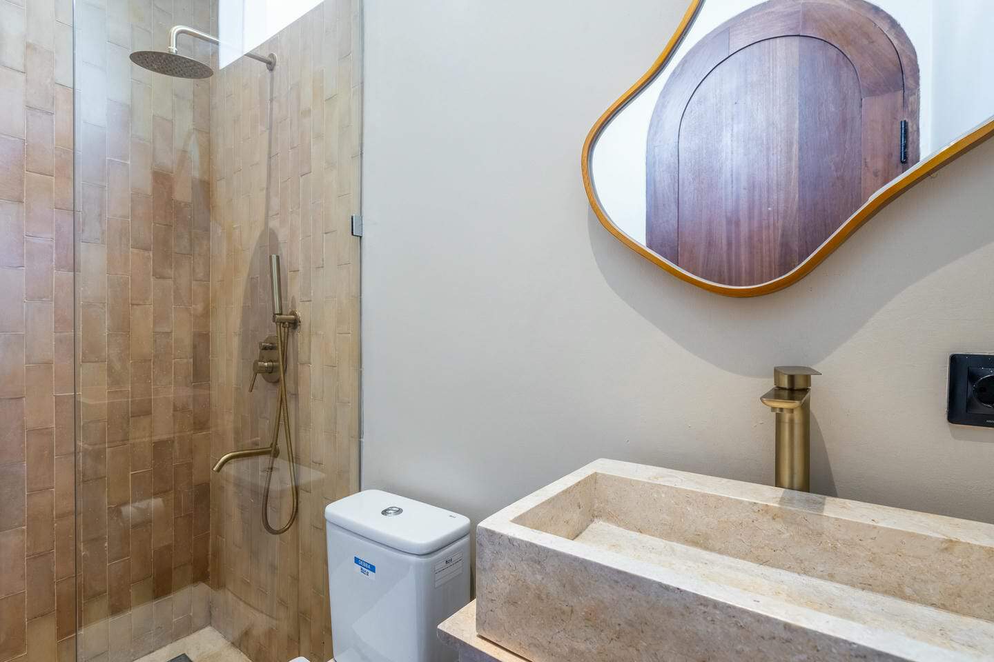 Modern bathroom with shower, toilet, and stone sink.