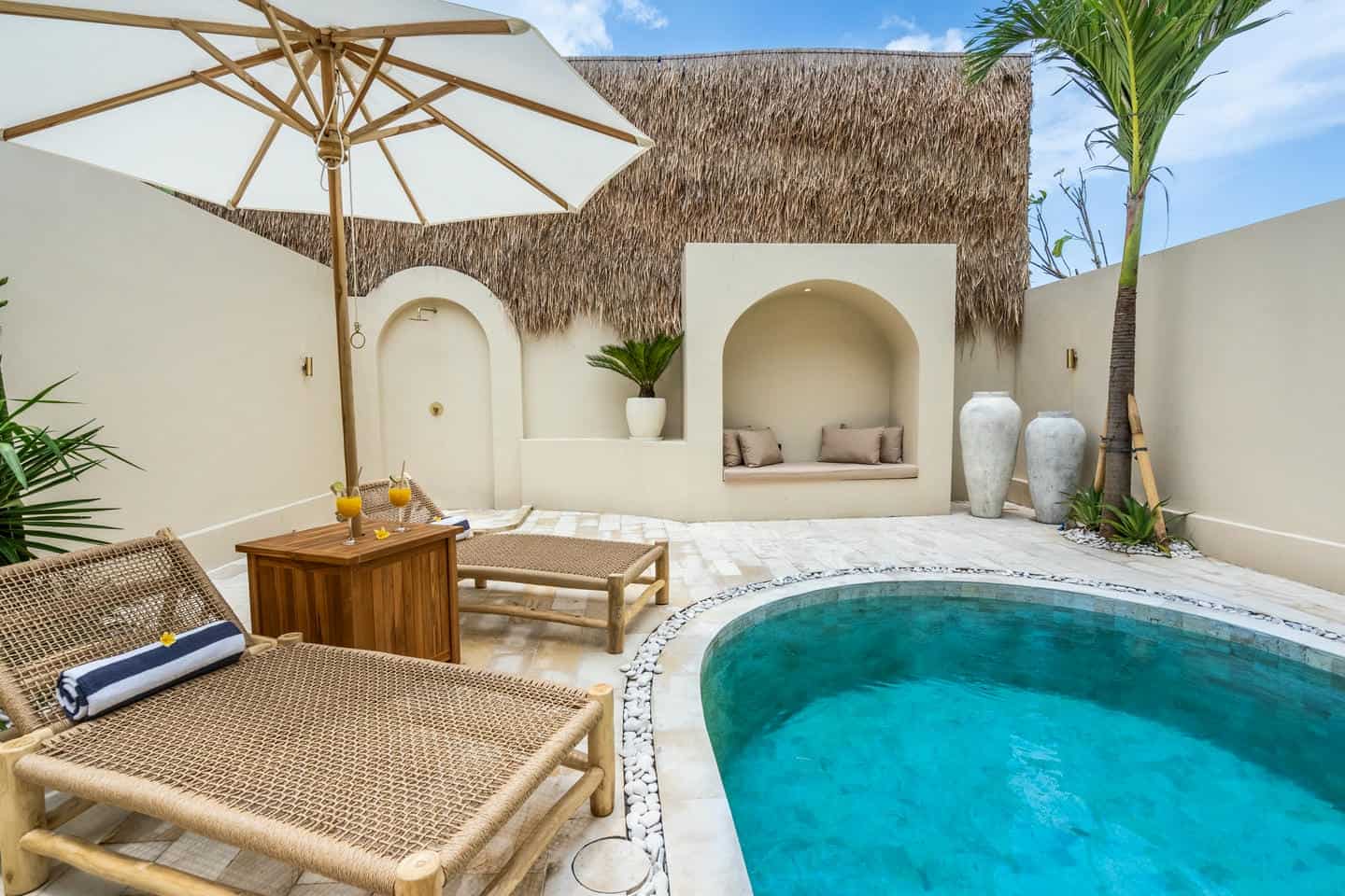 Luxurious outdoor pool with lounge chairs and umbrella.