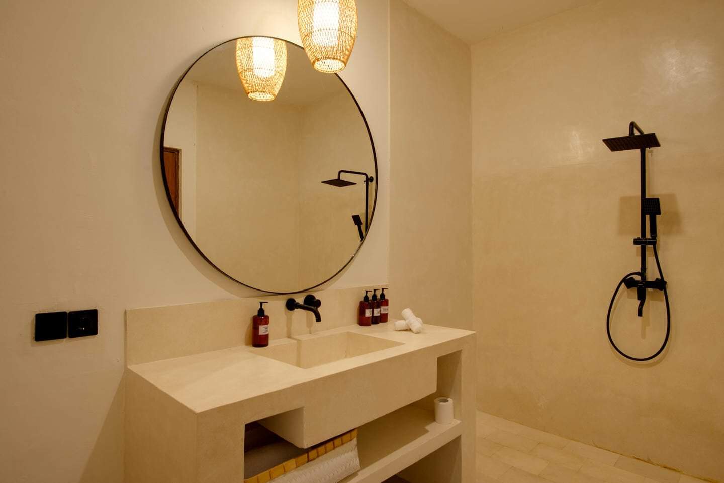 Minimalist bathroom with round mirror and shower.