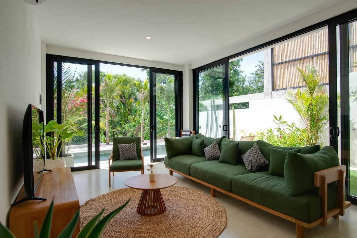 Modern living room with green sofa and garden view.