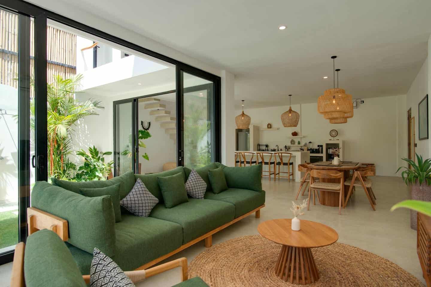 Modern living room with green sofa and open kitchen.