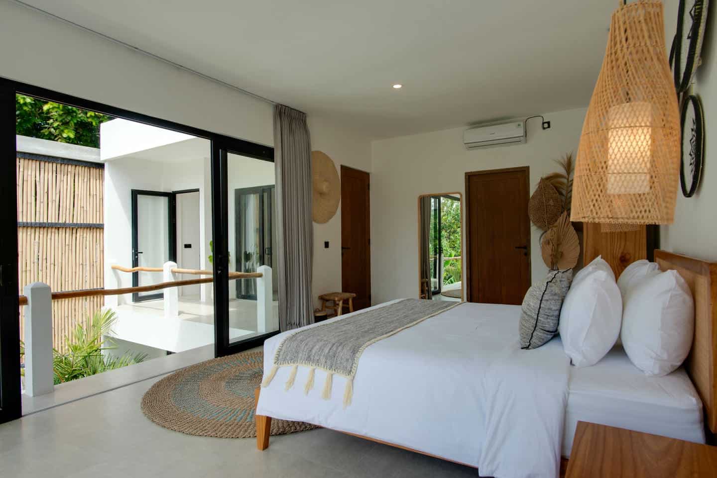 Modern bedroom with large glass doors, stylish decor.
