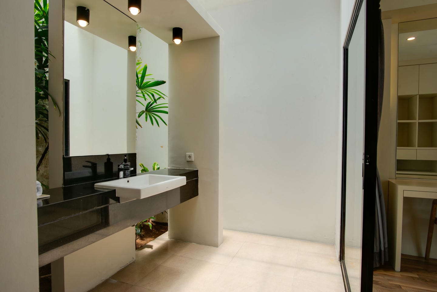 Modern bathroom with large mirror and greenery