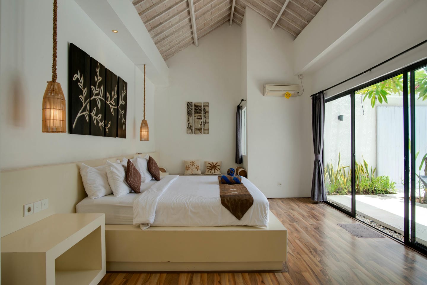 Modern bedroom with glass doors and wooden floor.
