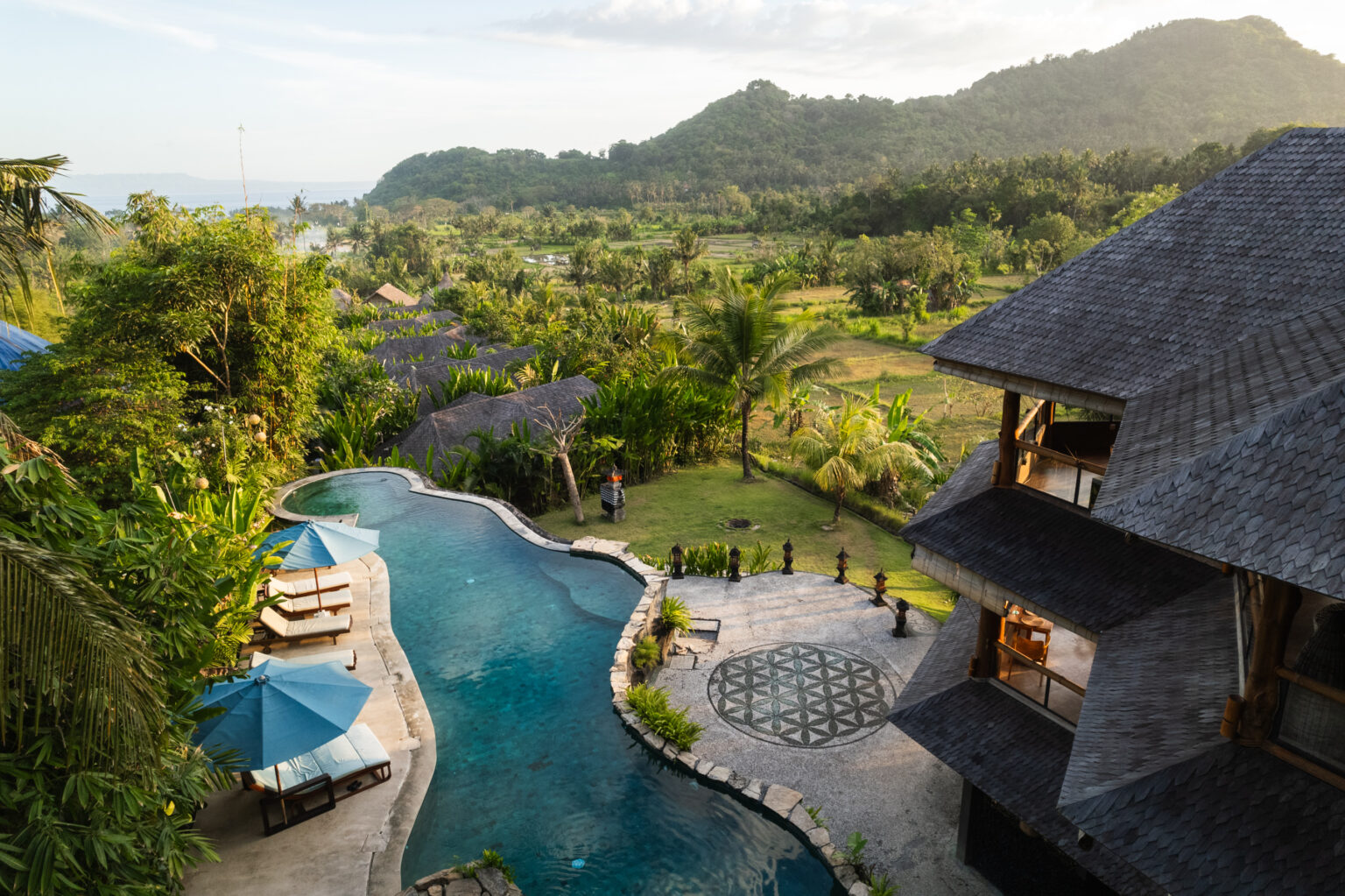 Resort with pool, tropical scenery, and mountains