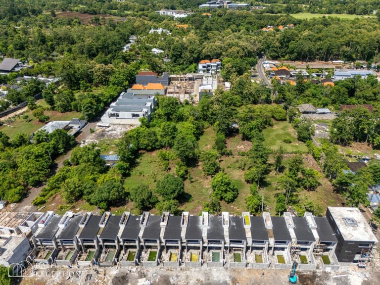 Aerial view of modern housing complex surrounded by trees.