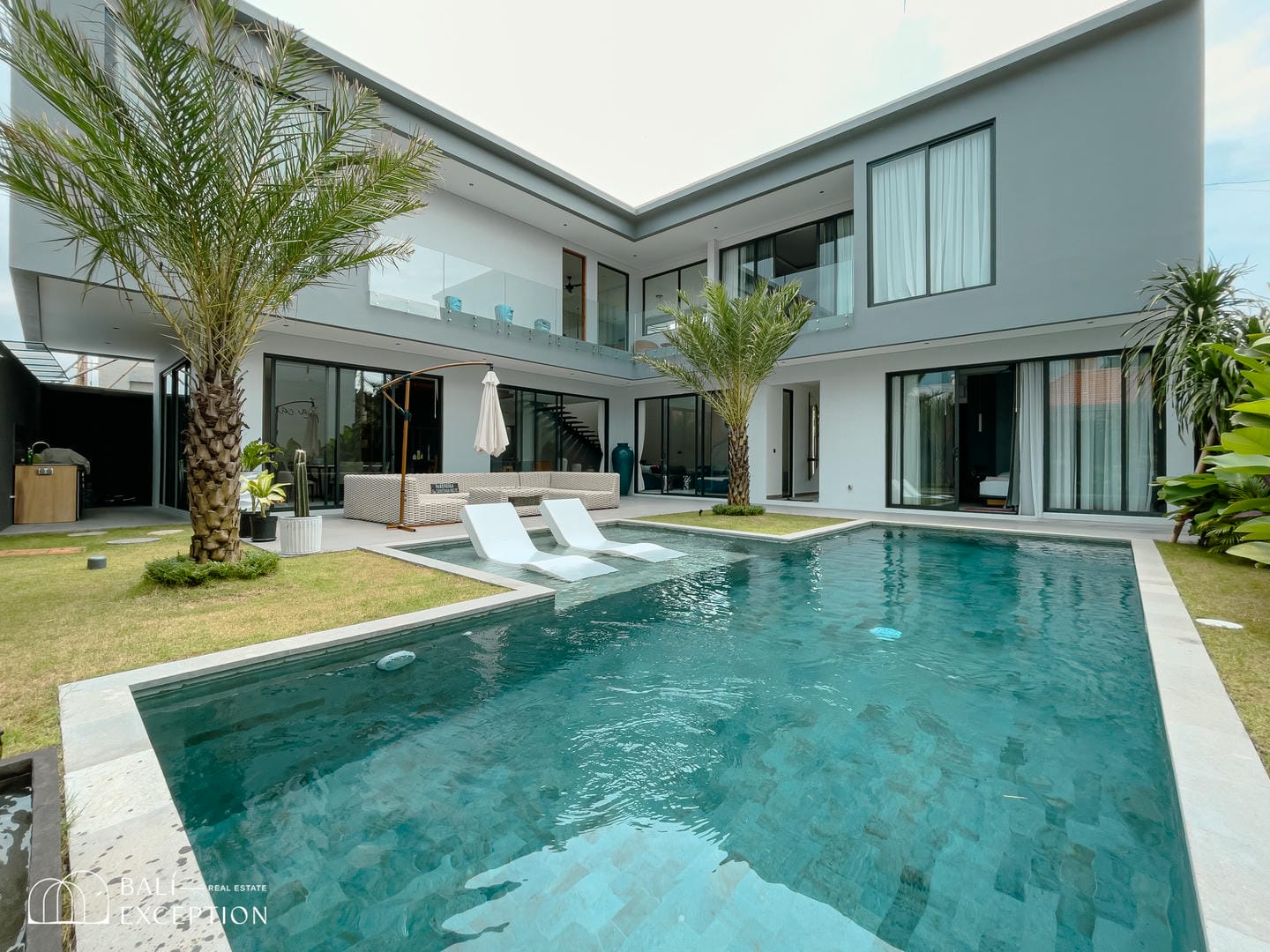 Modern luxury villa with pool and palm trees.