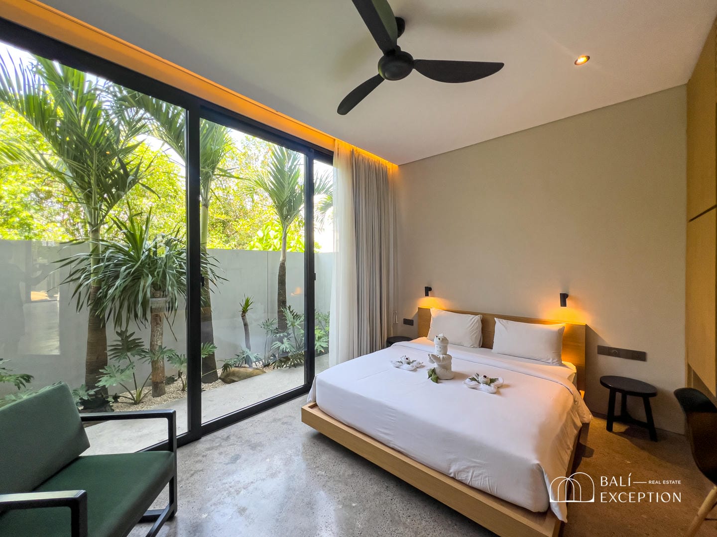 Modern bedroom with large window and tropical plants.