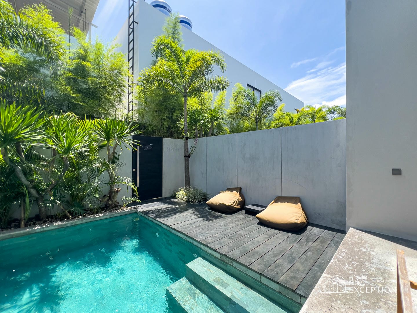 Modern patio with pool and lounge chairs.