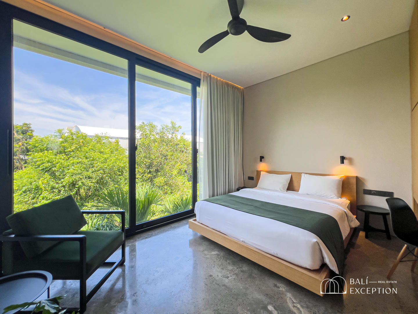 Modern bedroom with large window and greenery view.
