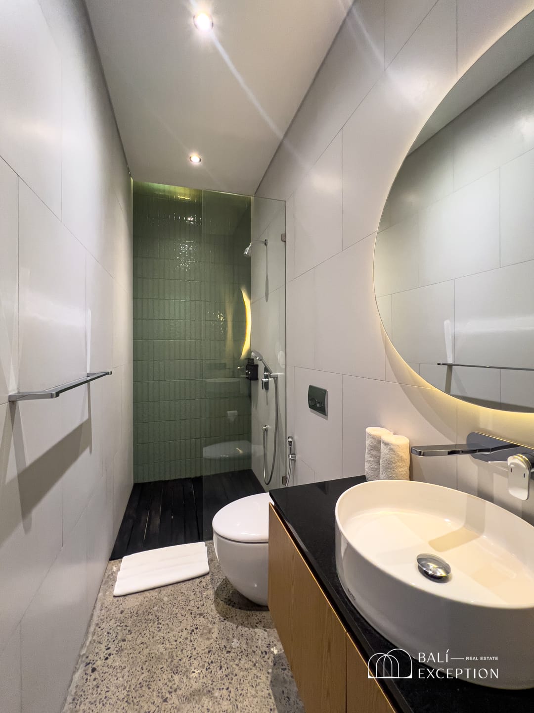 Modern minimalist bathroom with green tiled shower