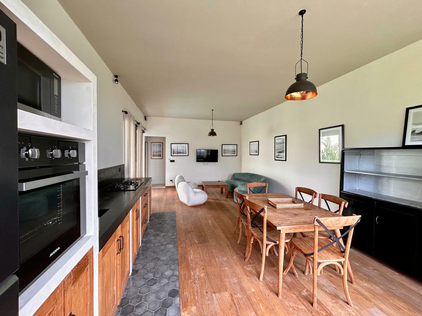 Modern kitchen-dining area with wooden furniture.