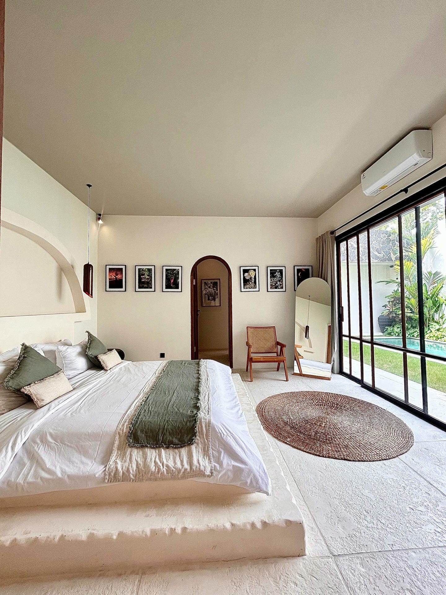 Modern bedroom with large bed and garden view.