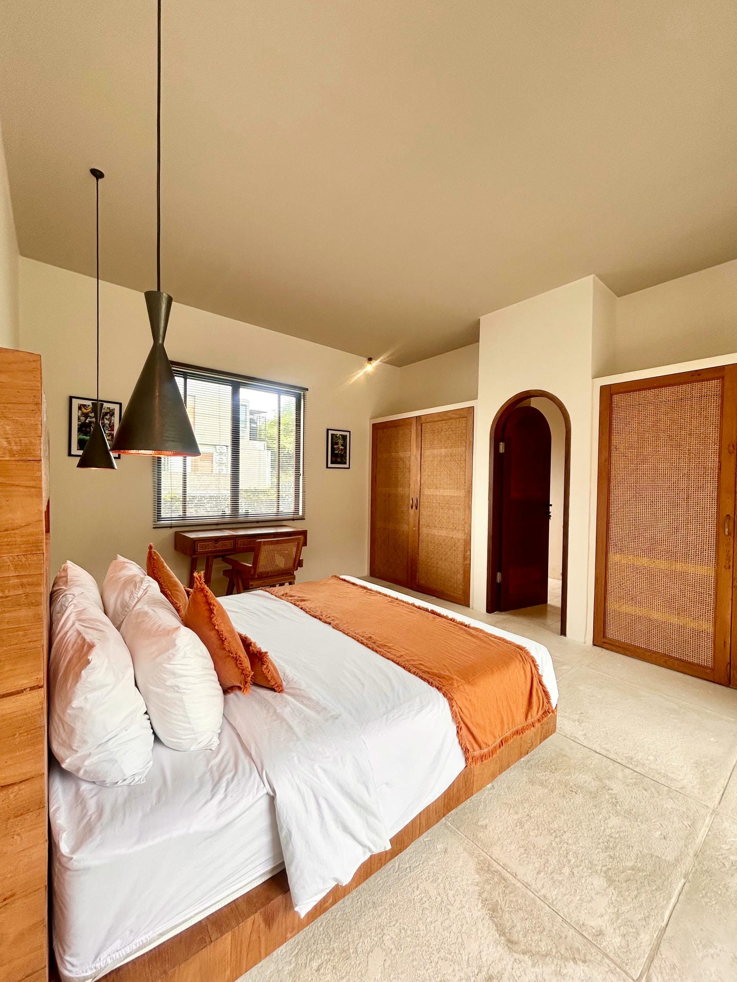 Modern bedroom with orange accents and wood furniture.