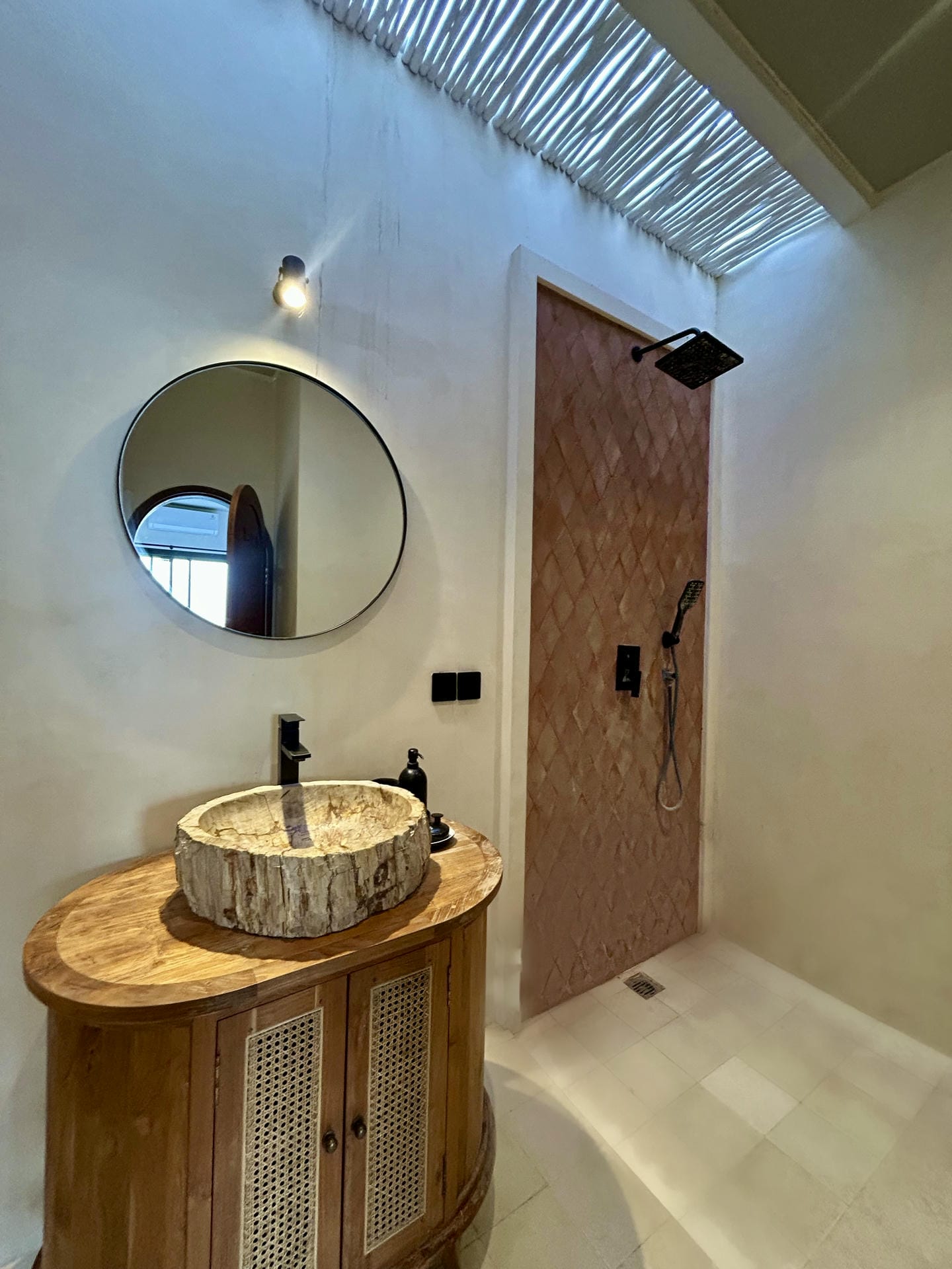 Modern bathroom with round mirror and stone basin