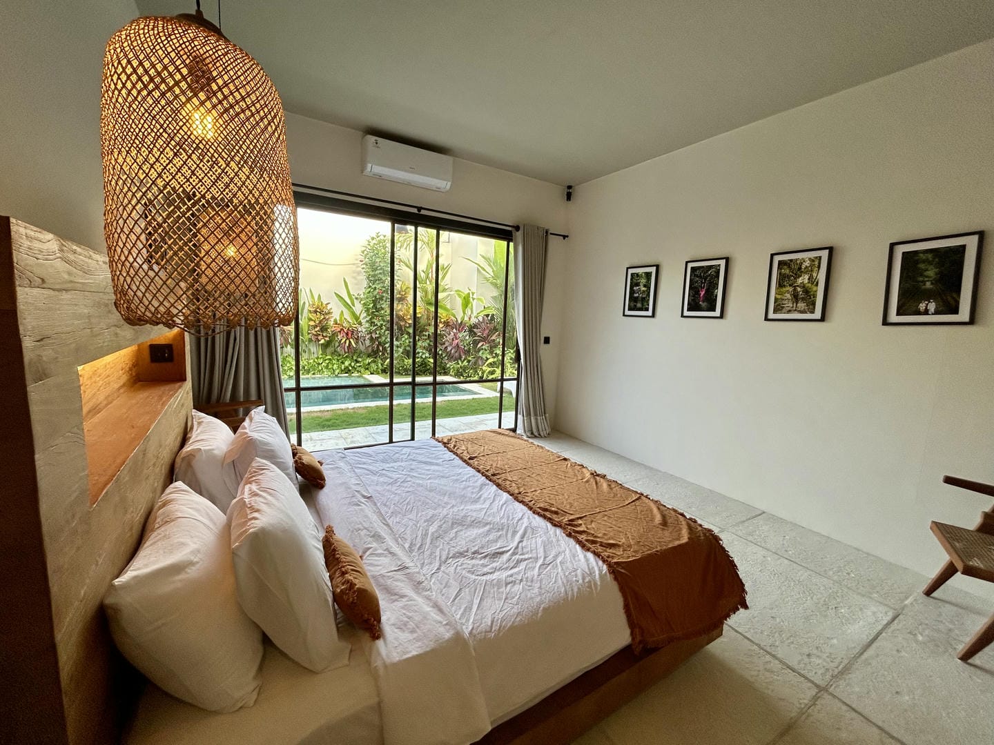 Modern bedroom with pool view and decor.