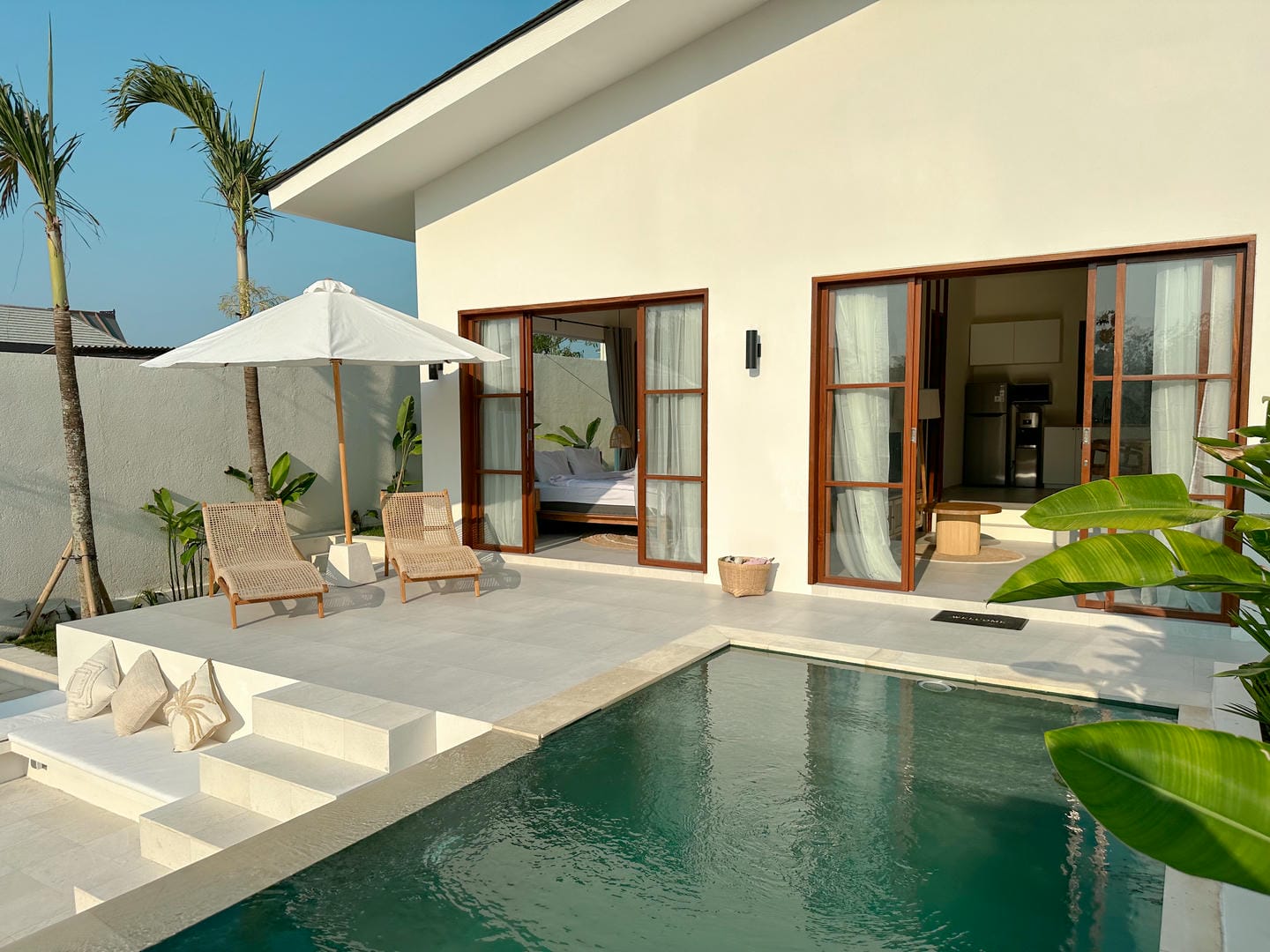 Modern villa with pool and sun loungers.