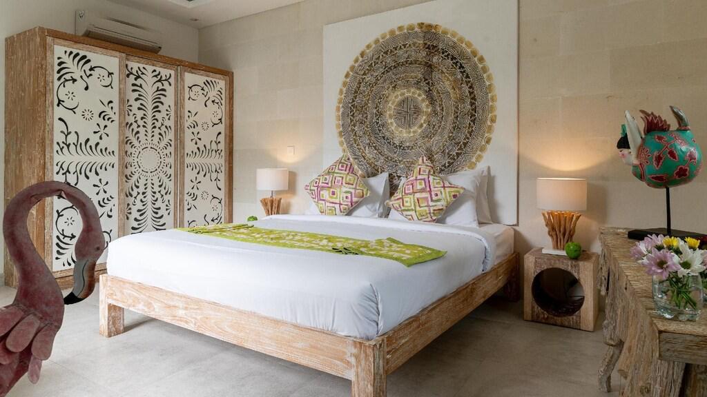 Bohemian bedroom with carved furniture and decor.