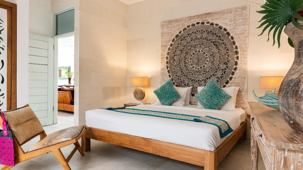 Cozy bedroom with decorative wall art and plants.