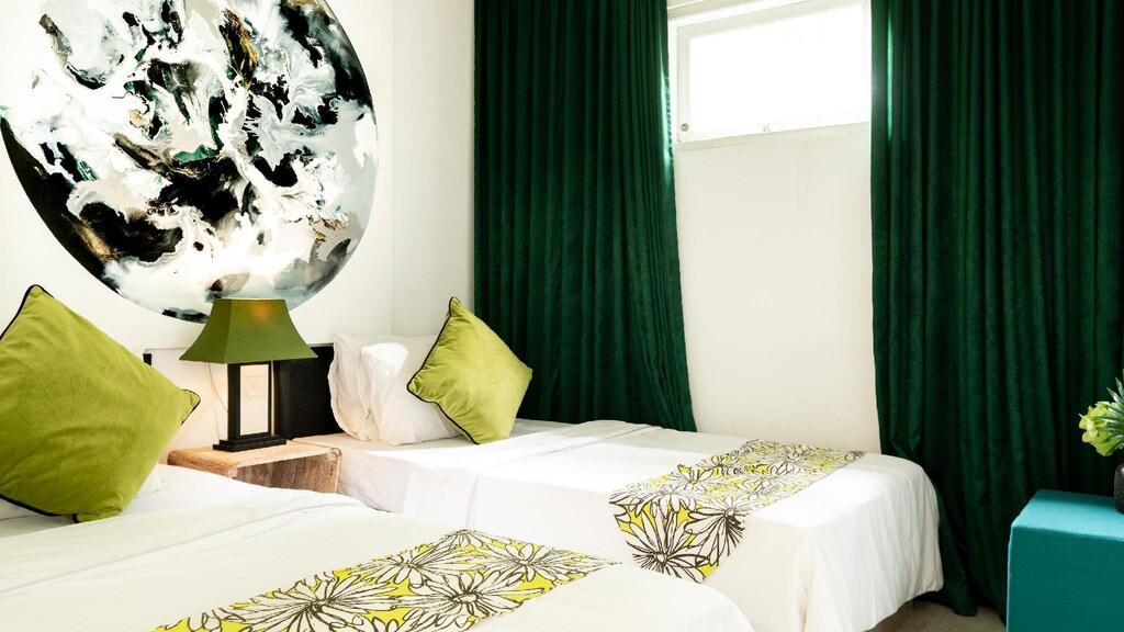 Contemporary bedroom with green accents and abstract art.