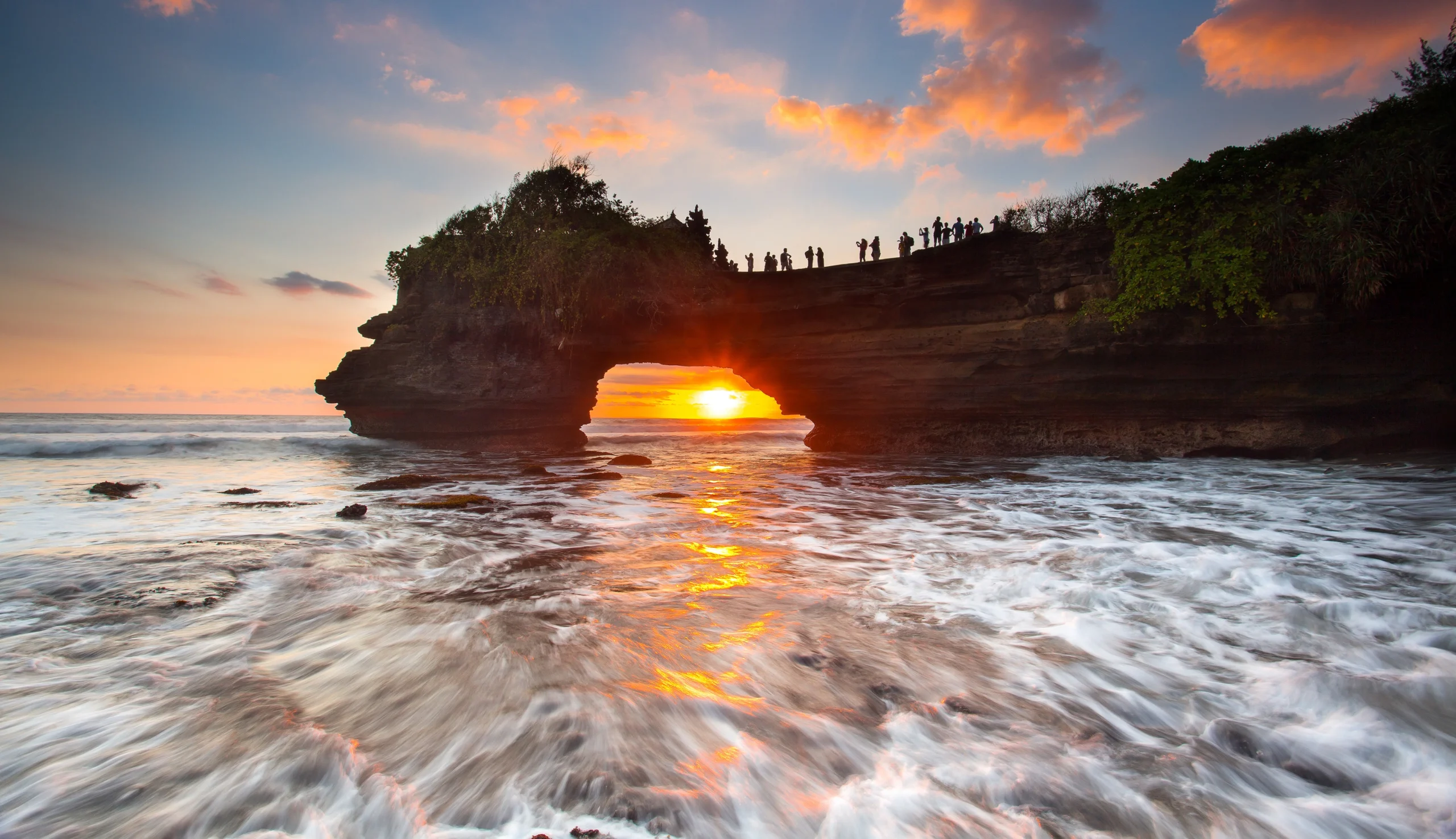 Sunset view through coastal rock archway