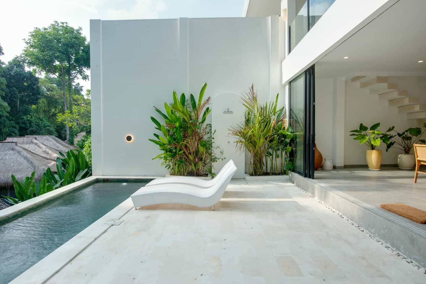 Modern villa patio with pool and greenery