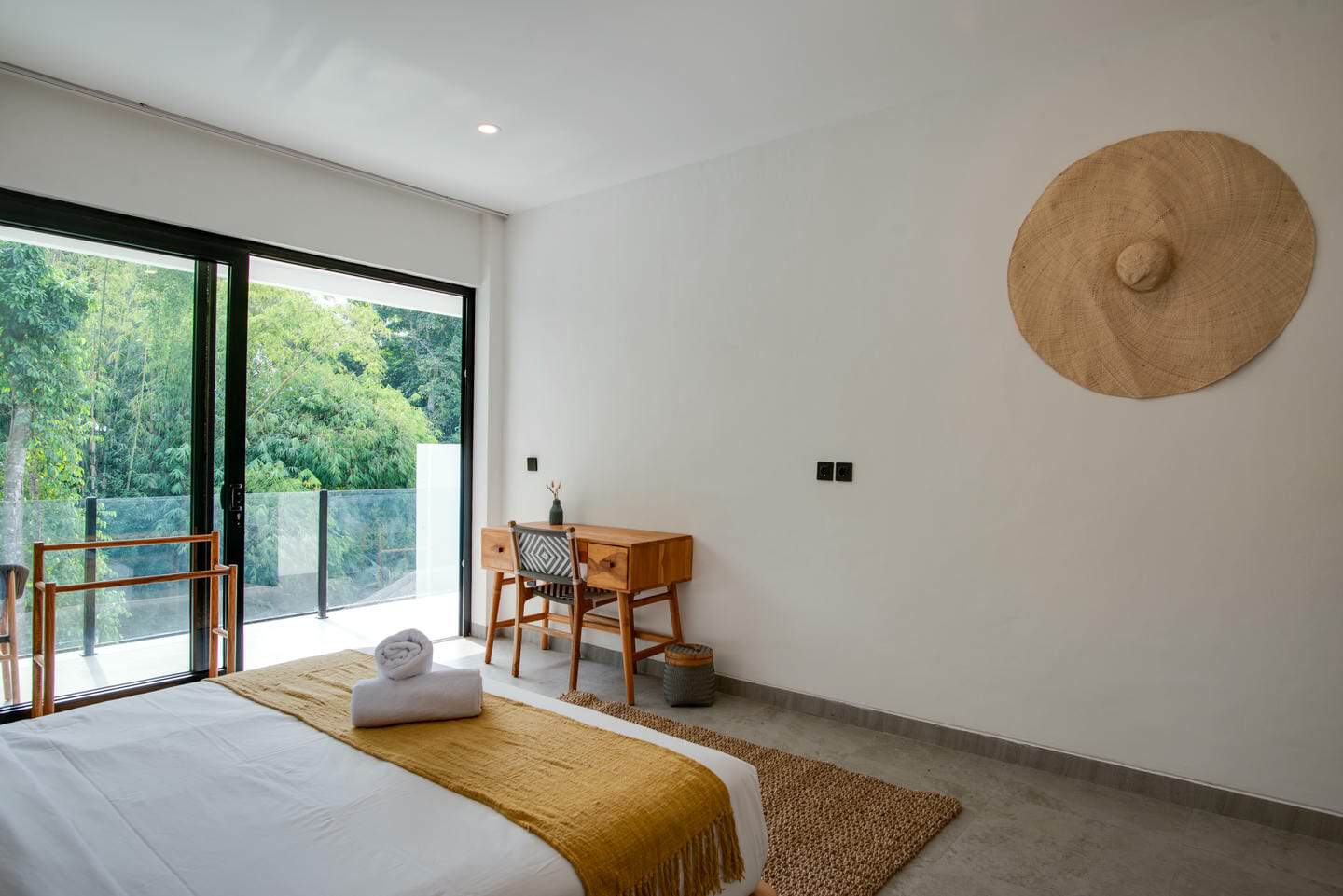 Minimalist bedroom with large window and wood accents.